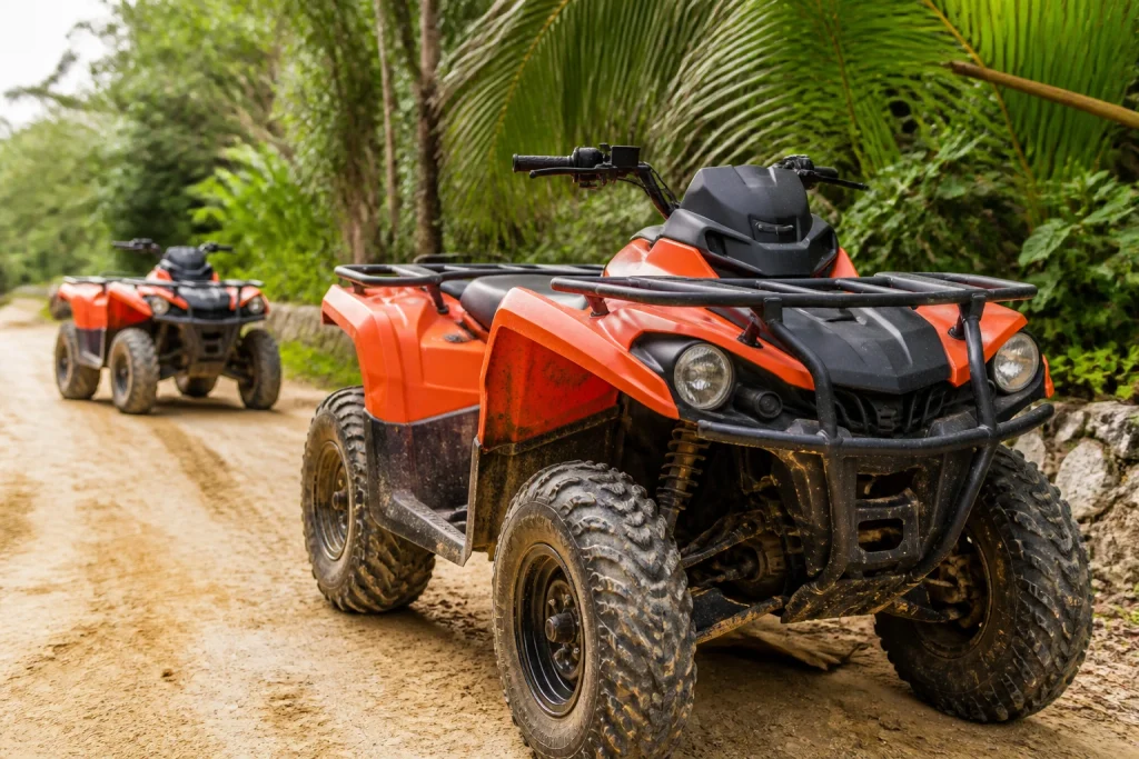 Off-road ATVs parked beside a tropical jungle trail.