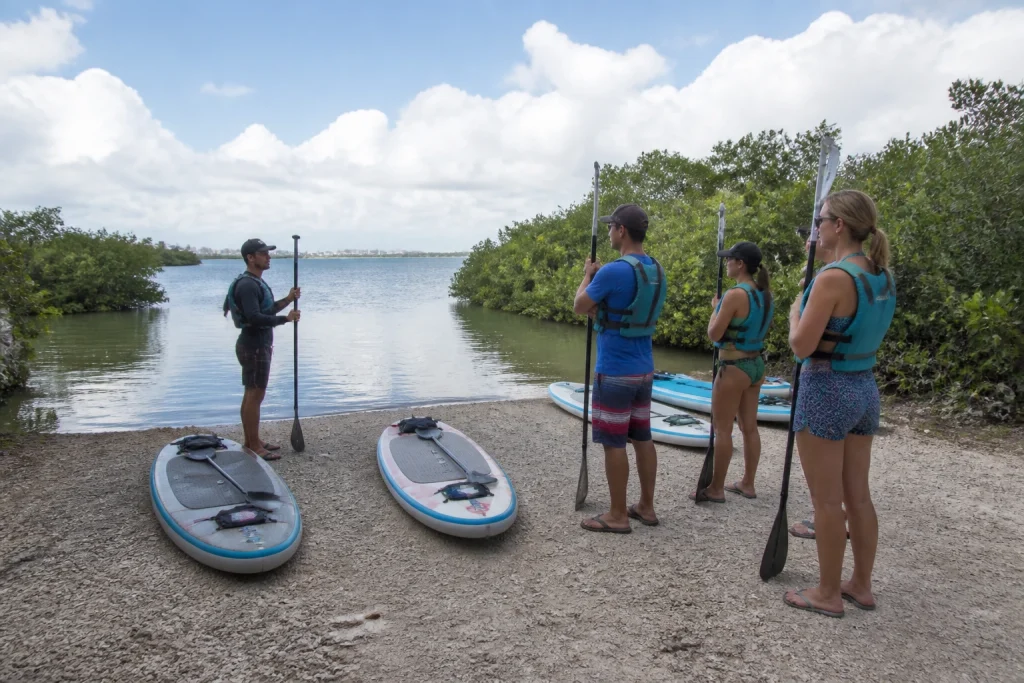 Guided paddleboard group preparing for a lagoon launch in Cancún