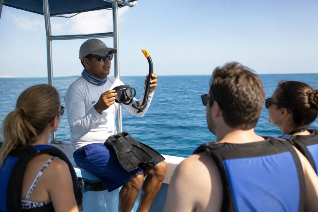 Guide demonstrating snorkeling equipment before a whale shark tour